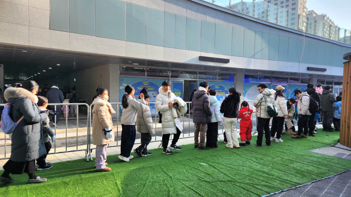 겨울 눈밭 놀이터 입장을 기다리는 시민들이 길게 줄을 서 있다.