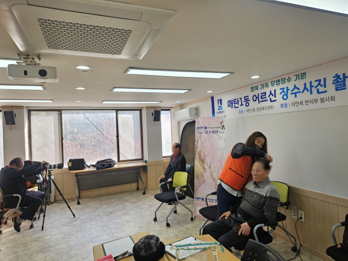 매탄1동에서 이만세 한식부 봉사회가 어르신 장수사진을 촬영하고 있다