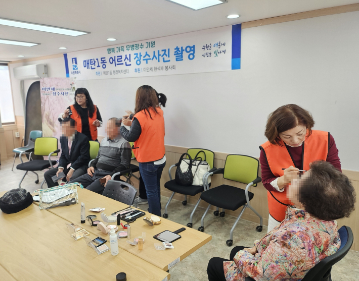 이만세 한식부 봉사회가 어르신에게 사진촬영을 위한 화장을 해드리고 있다 