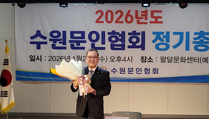 김운기 회장이 취임을 축하하는 꽃다발을 받고 환한 표정을 짓고 있다.