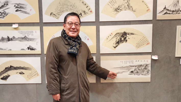 수원문인협회 김운기 회장이 작품 앞에서 포즈를 취하고 있다.