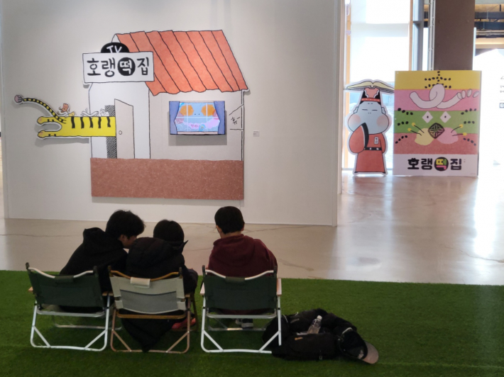 동화 『호랭떡집』 앞에서 초등학생 관람객들이 전시 관람 후 저마다의 언어로 감상을 나누고 있다.