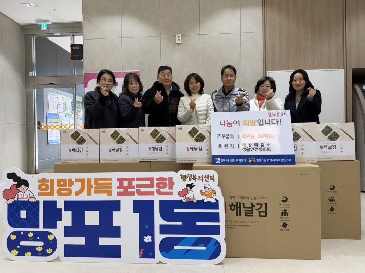 태장파출소(소장 문성구,오른쪽 세번째) 생활안전협의회(회장 김지철, 왼쪽 세번째) 에서 망포1동(동장 김영희, 중앙)에 조미김 50박스를 전달하고 기념촬영을 하고 있다