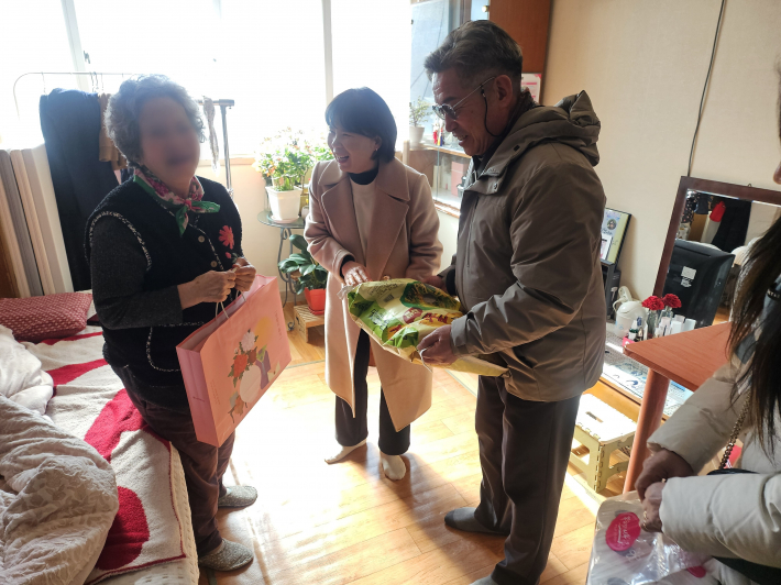 매탄1동 단체연합회에서 어르신 가정을 방문하여 후원물품을 전달하고 있다