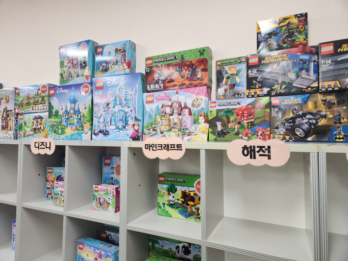 벽면 가득  조립 가능한 레고 블럭이 시리즈 구분되어 있다.