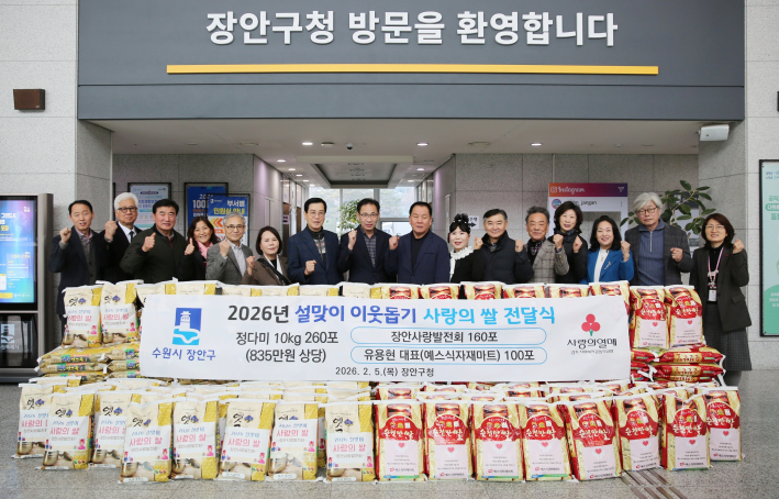 장안사랑발전회 회원들이 기부할 쌀 앞에서 웃고 있다.