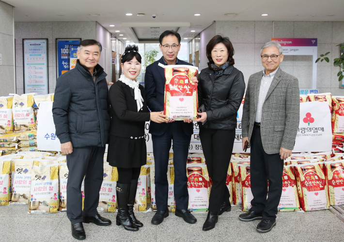 장안사랑발전회 정책분과 위원들이 예스식자재마트에 기부한 쌀을 들고 웃고 있다