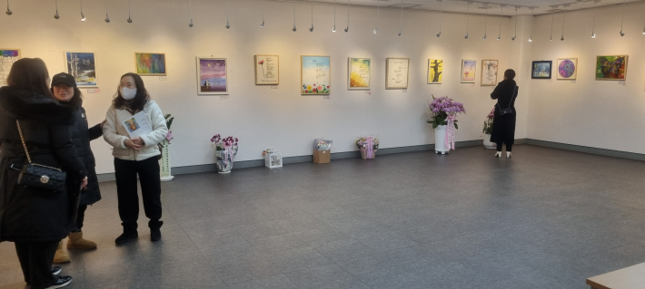 전시장을 찾은 동료들에게 작품에 대해 설명하는 추인영 작가