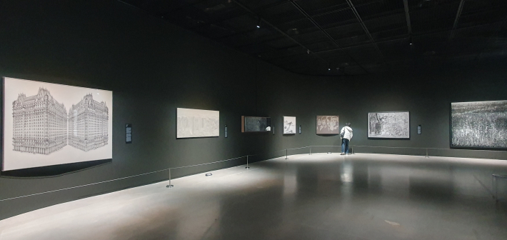 전시장 중앙, 작품을 응시하는 관람객과 곡선 벽면을 따라 흐르는 전시의 호흡