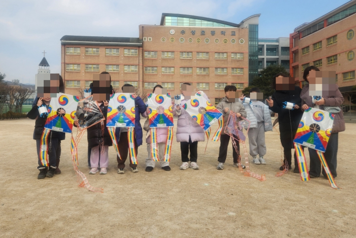 어린이들과 학부모들이 연날리기행사 참여 후 사진촬영을 하고있다.