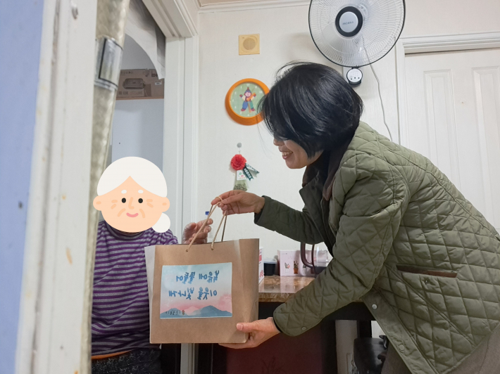 ▲ 수원성북교회에서 후원한 설맞이 반찬세트를 어르신들께 전달하는 사진