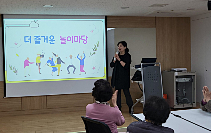 김영언 강사가 어르신들에게 '더즐거운 놀이마당' 보드게임 규칙을 차근차근 안내하고 있다.