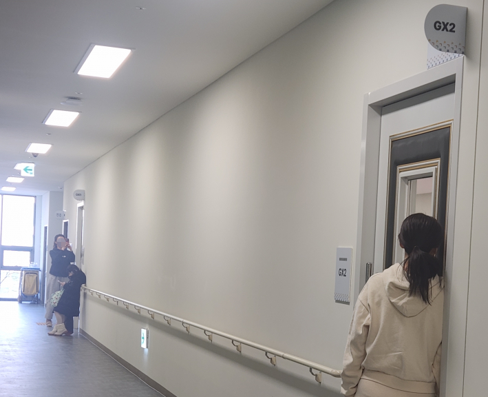 수업이 진행되는 GX실 출입문 작은 창문 앞에서 보호자들이 아이들의 모습을 지켜보고 있다.