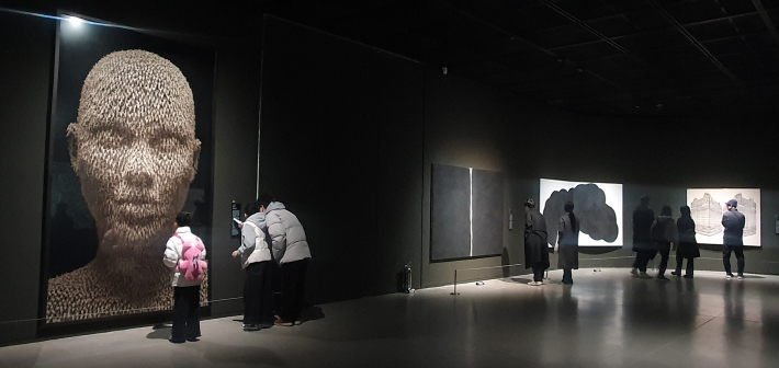 설 연휴 기간 전시장을 찾은 시민들이 작품 앞에서 발걸음을 늦추고 감상을 나누는 모습