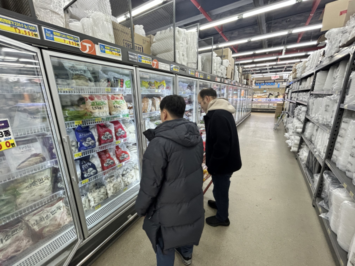 복잡한 진열대 사이에서 유통기간을 확인하고 식재료를 고르는 눈빛들이 자못 진지하다