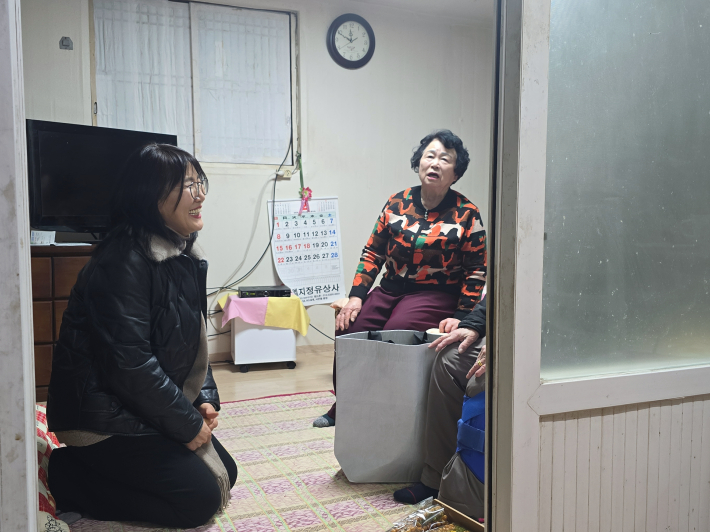 어르신들이 직접 만든 강정을 들고 몸이 편찮으신 주민 댁을 방문해 따뜻한 인사를 전하고 있다.