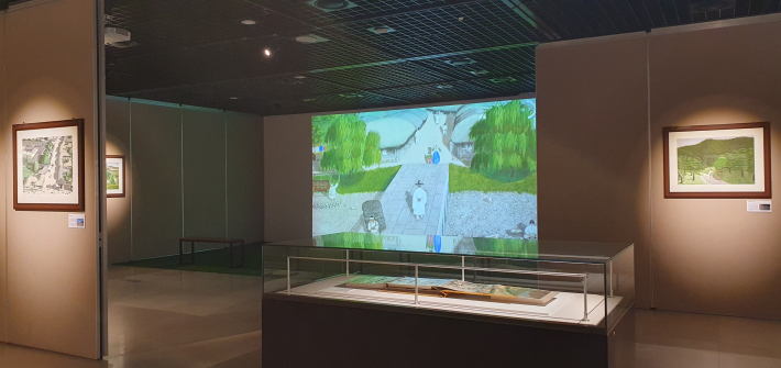 전시장 가운데 유리 진열장 안에 길게 펼쳐진 소중한 미공개 종이 스케치 원본