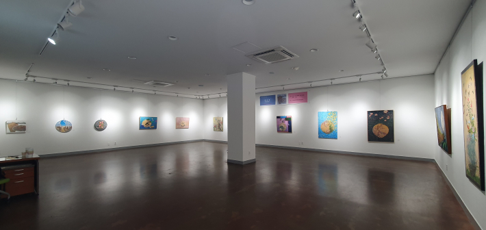 전시장 내부. 원형 캔버스와 사각 캔버스가 어우러져 벽면을 채우고 있다.