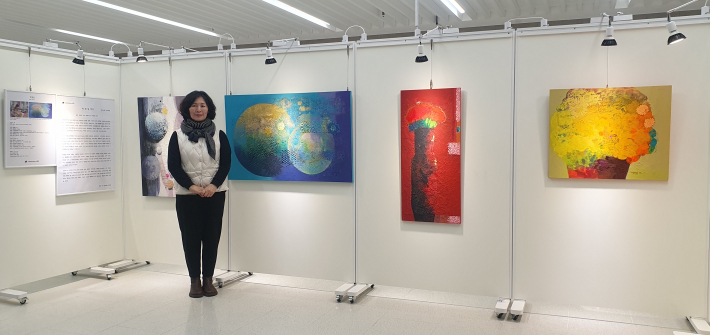 박정일 작가가 자신의 추상 회화 작품들 앞에 서 있는 모습