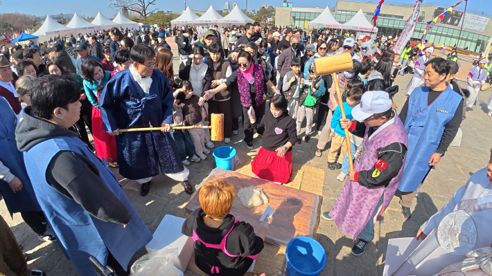 어울림 헤라가 준비한 대보름 맞이 떡메치기가 한창 진행되고 있어 많은 시민이 몰려 있다.