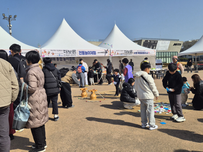 제기만들기,제기차기, 투호놀이, 딱지치기 등 시민들이 흥겨운 전통놀이를 하고있다