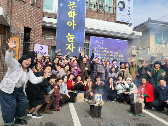 정월대보름 행사 후 참가자들이 저마다의 제스처로 즐거운 기념사진을 남겼다. 뒤편에 걸린 백드롭 플래카드가 행사 분위기를 한층 돋보이게 한다.