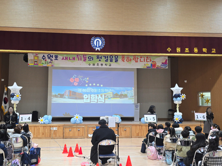 수원초등학교 강당에서 열린 제46회 입학식에 신입생과 학부모들이 참석해 있다.