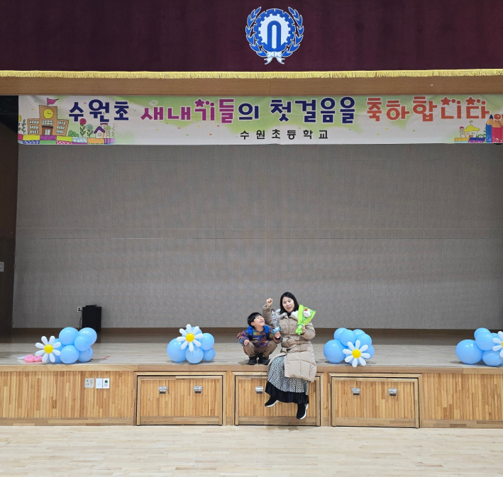 입학식을 마친 뒤 필자의 아이와 필자가 수원초등학교 강당 앞에서 기념촬영을 하고 있다.