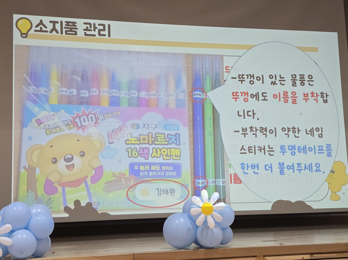 수원초등학교 입학식에서 학부모들에게 안내된 소지품 관리 방법. 모든 학용품에 이름을 붙이고, 네임스티커 위에 투명테이프를 덧붙이는 방법을 설명하고 있다.