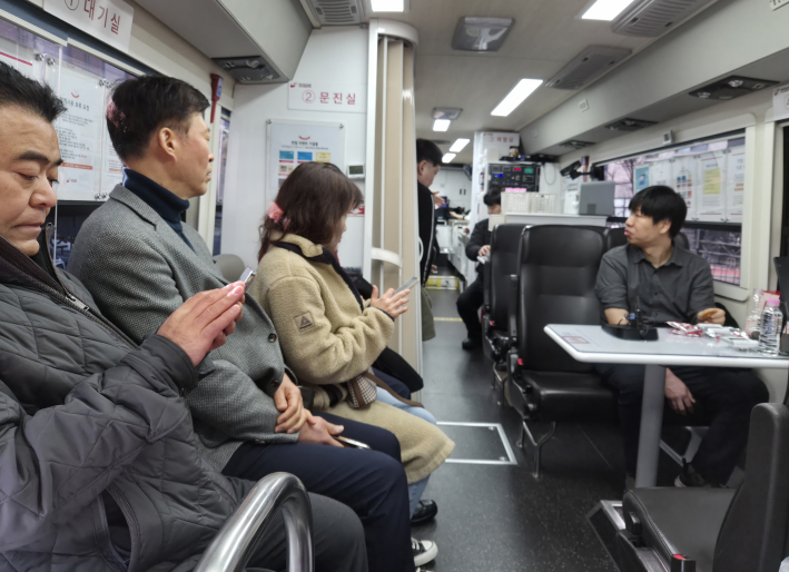 헌혈 참여자들이 대기실에서 전자문진을 통해 건강 상태를 확인하고 있다.