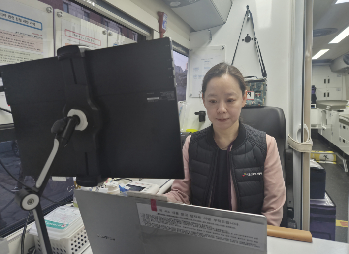 대한산업보건협회 부설 한마음혈액원 김연욱 간호사가 헌혈버스에서 채혈 업무를 진행하고 있다.
