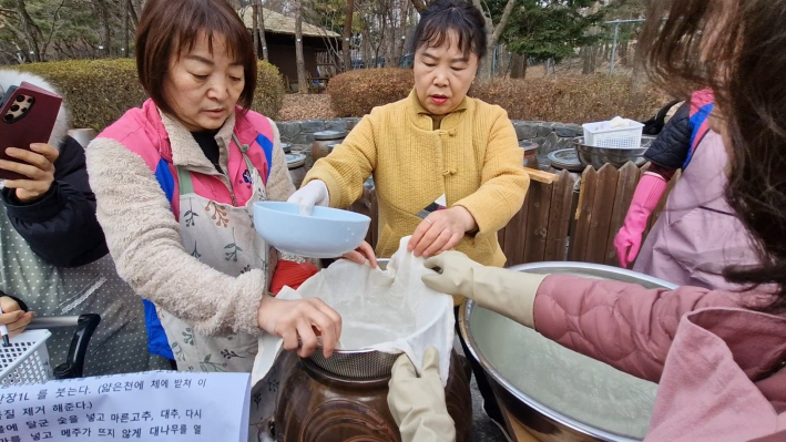 항아리에 메주를 넣고 소금물을 걸러 넣는다.
