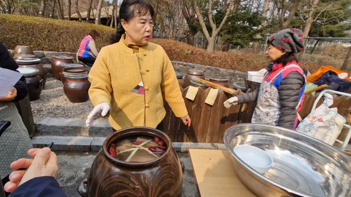 장 담그기를 끝내고 위에 대나무를 십자로 올리고 붉은 고추, 대추, 숯을 넣는다.