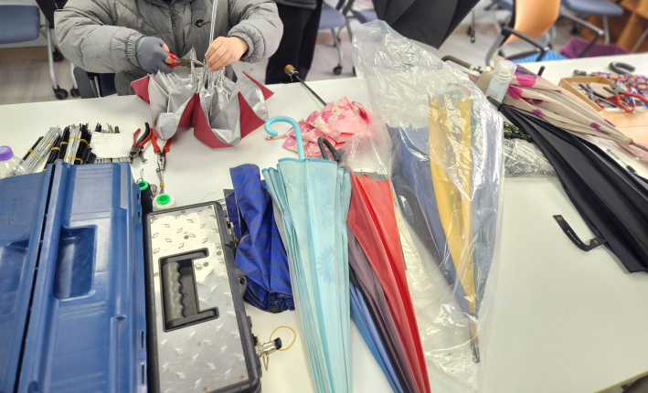 우산살 교체와 부품 정비를 통해 고장 난 우산을 다시 사용할 수 있도록 수리하는 모습.