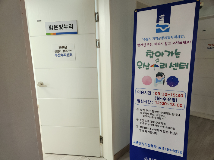 찾아가는 우산수리센터 이용시간을 안내하는 입간판.