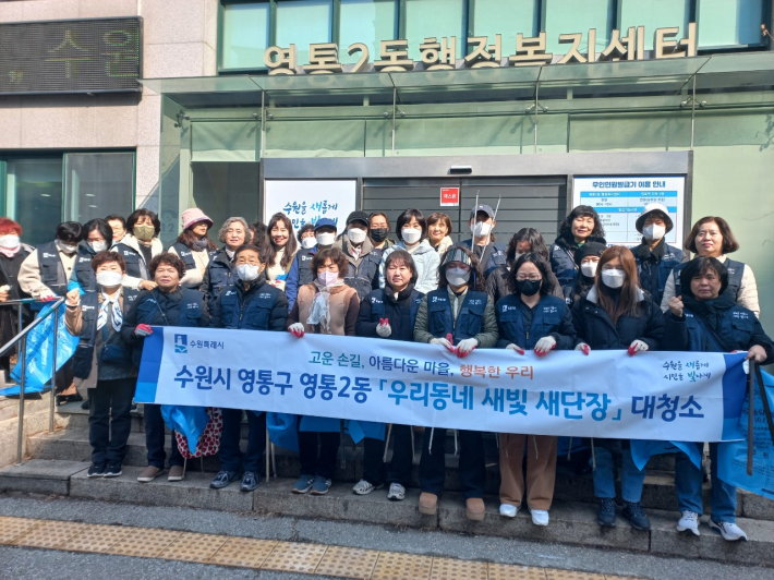 영통2동 통장협의회 위원들이 현수막을 들고 사진을 찍고 있다.