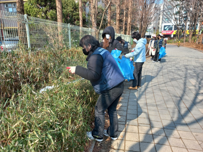 청소 봉사자들이 풀숲에 숨어있는 쓰레기들을 꼼꼼히 살피고 있다.