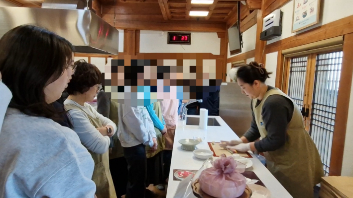 떡 만들기 시범을 보여주고 있는 선생님