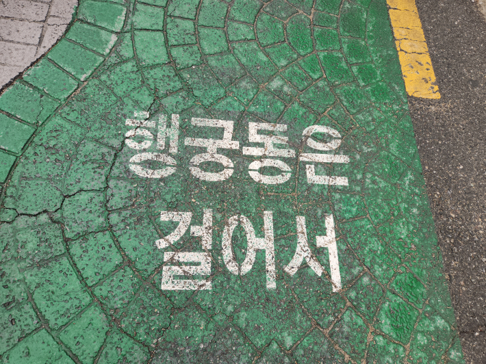 행궁동 골목길 바닥에 표시된 '행궁동 골목길 여행' 안내 문구. 골목을 따라 걸으며 다양한 역사와 문화 이야기를 만날 수 있다.