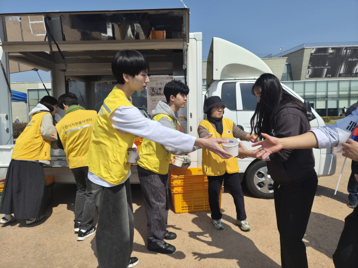 주먹밥으로 끼니를 해결하던 그날의 마음을 담은 주먹밥을 시민들에게 나누어주고 있다