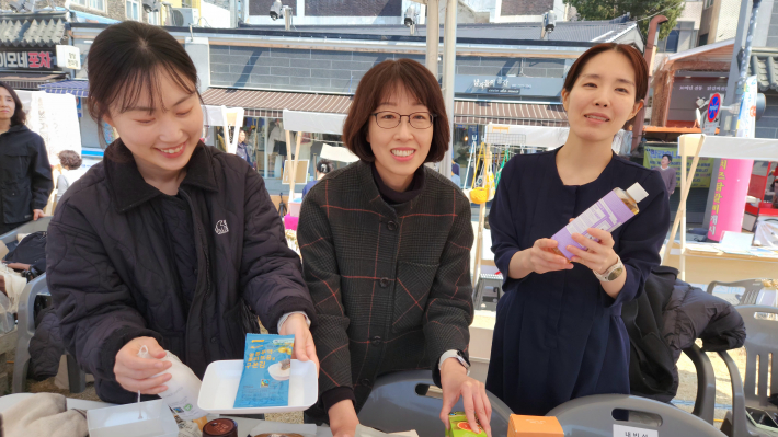 수원공정무역협의회 부스에서 관계자들이 공정무역 제품을 소개하며 인터뷰에 응하고 있다.