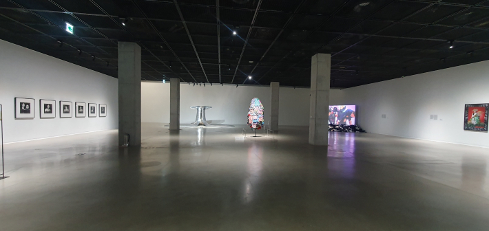 서도호가 수많은 군번표를 엮어 만든 갑옷 형상 작품 〈Some/One〉과 벽면에 나란히 걸린 오형근 사진 연작 〈아줌마〉가 전시된 공간