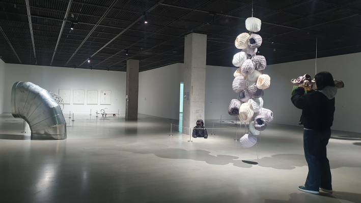 연진영이 대량생산 과정에서 버려진 패딩 모자 수십 개를 쇠사슬로 엮어 기둥 형태로 만든 조형물 〈빈 타워 가드(Empty Tower Guard)〉