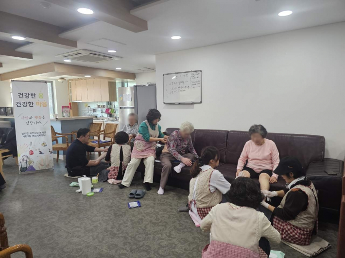 발사랑이웃사랑 봉사단이 매탄3동 하늘채경로당 어르신들에게 발마사지 봉사를 진행하고 있다. 