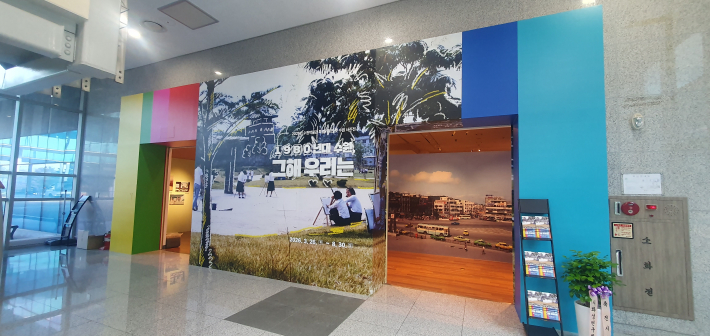 '1980년대 수원, 그해 우리는'이라는 대형 타이틀과 옛 사진 래핑으로 화려하게 꾸며진 전시실 입구 전경