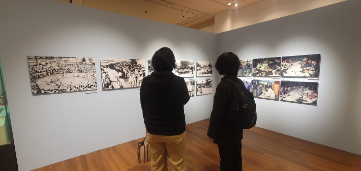 인터뷰를 마친 관람객이 벽에 걸린 옛 사진들에 다가가 아주 집중해서 들여다보고 있는 모습