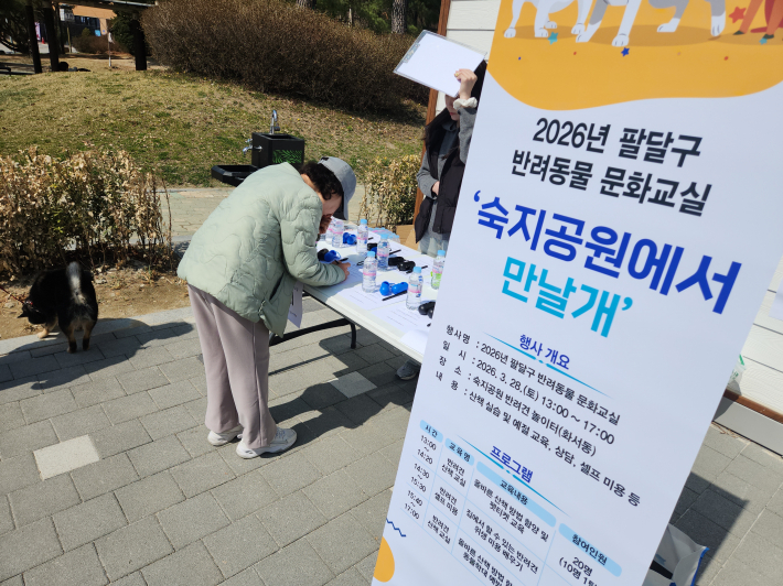 반려견과 함께 공원을 찾은 시민들이 산책 예절 교육 프로그램에 현장 접수를 하고 있다.