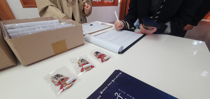 관람객들이 고객만족도 조사에 참여한 뒤 기념품을 받고 있다