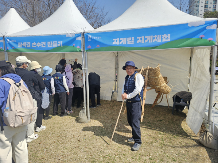 지게체험코너에서 지게를 져보는 이태호 사진가