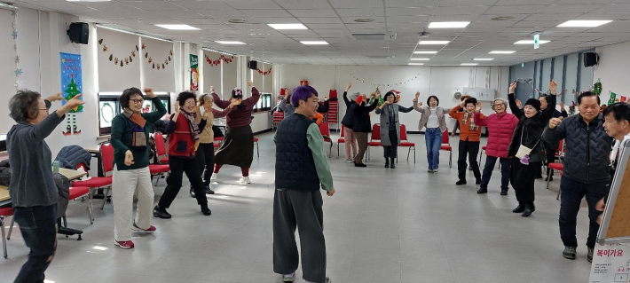 참여자들이 음악에 맞춰 신체 활동을 하며 즐겁게 교류하고 있다.